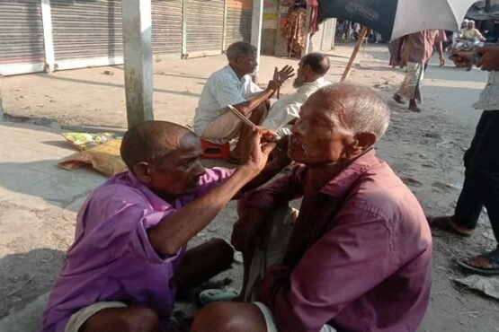 হারিয়ে যাচ্ছে মাটিতে বসে চুল দাড়ি ছাঁটা