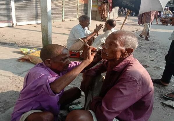 হারিয়ে যাচ্ছে মাটিতে বসে চুল দাড়ি ছাঁটা
